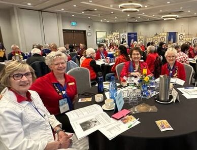Catholic Women's League members smiling and gathering around tables at a convention